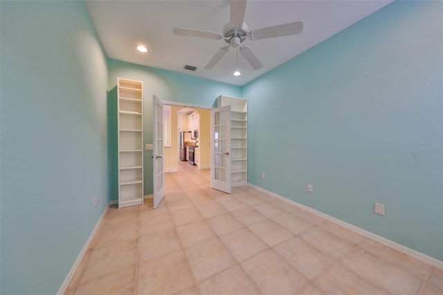 empty room featuring ceiling fan and french doors