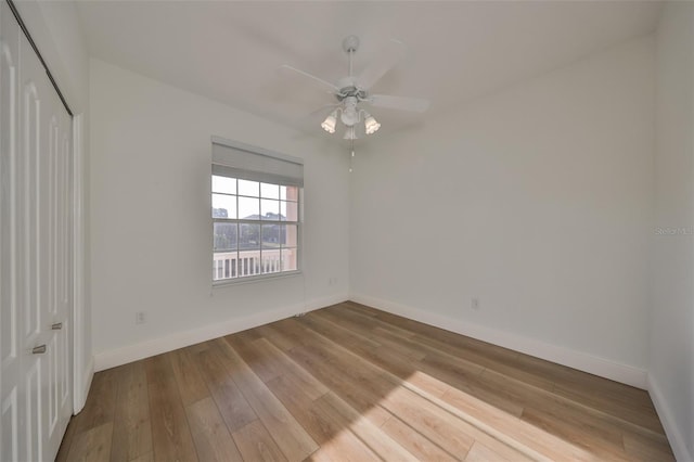 unfurnished bedroom featuring ceiling fan, light hardwood / wood-style floors, and a closet