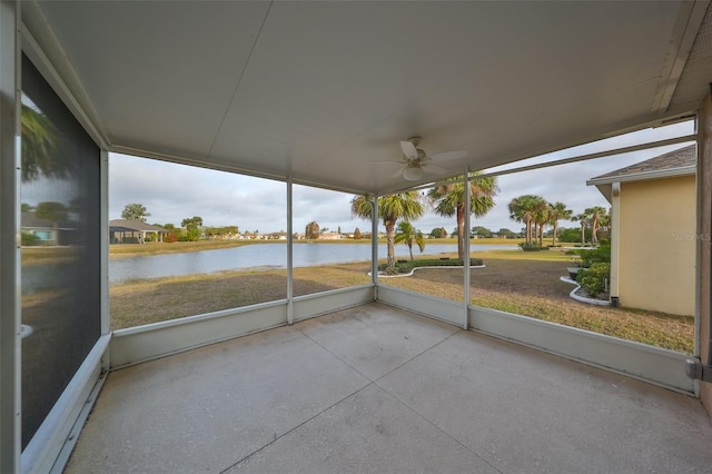 unfurnished sunroom with a water view and ceiling fan