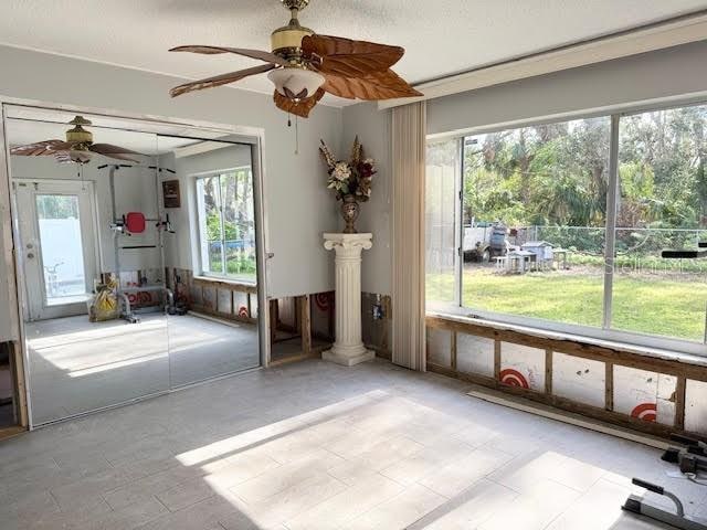 interior space featuring ceiling fan and decorative columns