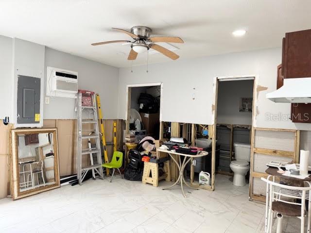 miscellaneous room featuring a wall unit AC, electric panel, and ceiling fan