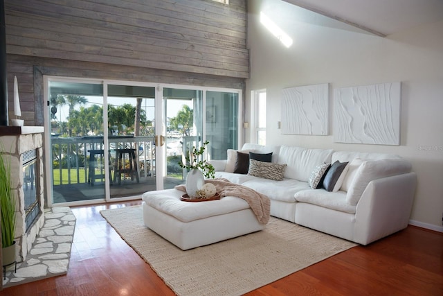 living room with a fireplace, hardwood / wood-style flooring, and high vaulted ceiling