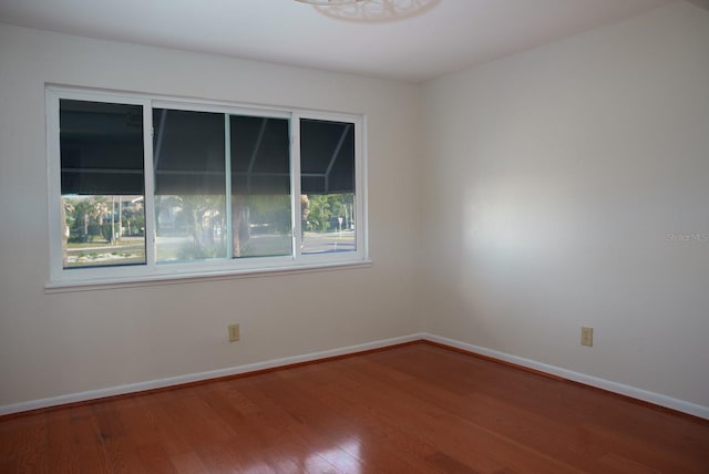 empty room with a healthy amount of sunlight and wood-type flooring