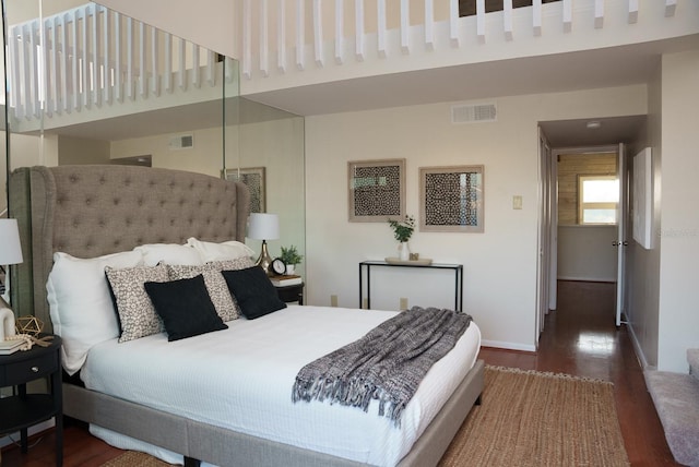 bedroom featuring a high ceiling and dark hardwood / wood-style floors