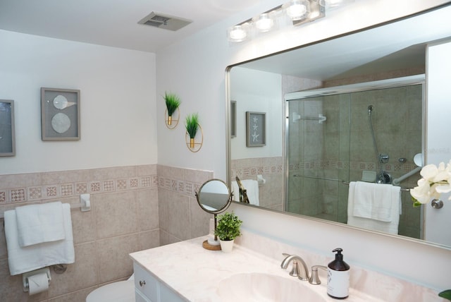 bathroom featuring toilet, tile walls, walk in shower, and vanity