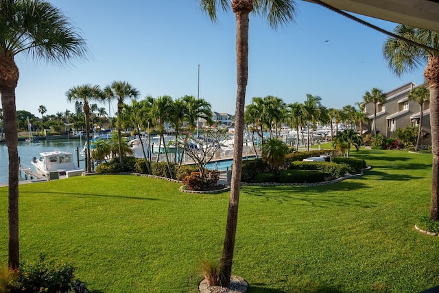 view of home's community with a water view and a lawn