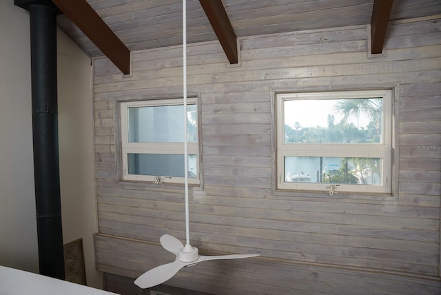 bathroom featuring wood walls, a wood stove, beam ceiling, and wooden ceiling