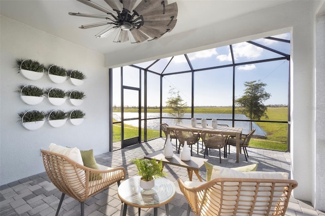 sunroom featuring a water view