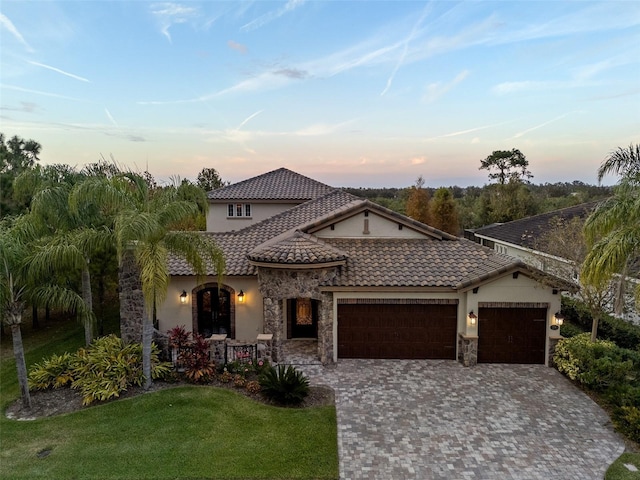 mediterranean / spanish house featuring a yard and a garage