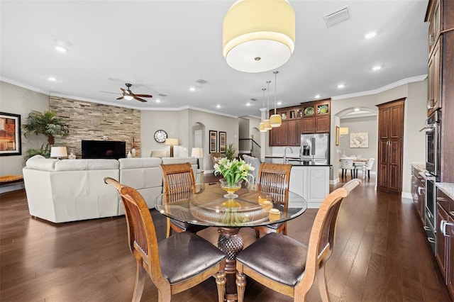 dining room with ceiling fan, dark hardwood / wood-style flooring, ornamental molding, and sink