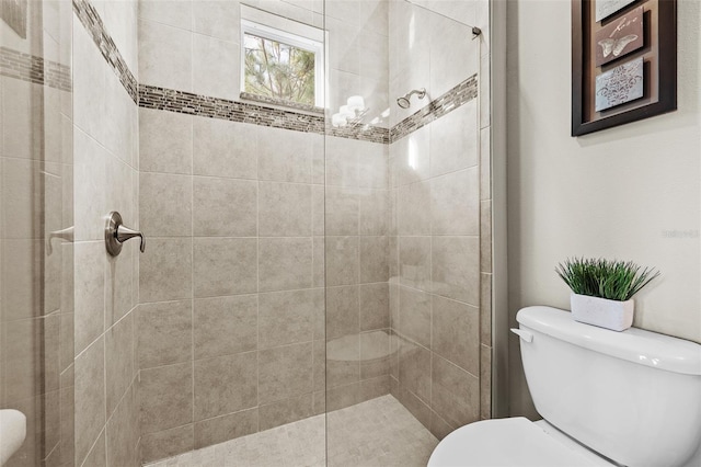 bathroom featuring a tile shower and toilet