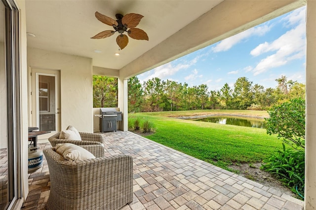 view of patio / terrace featuring a water view, ceiling fan, and a grill