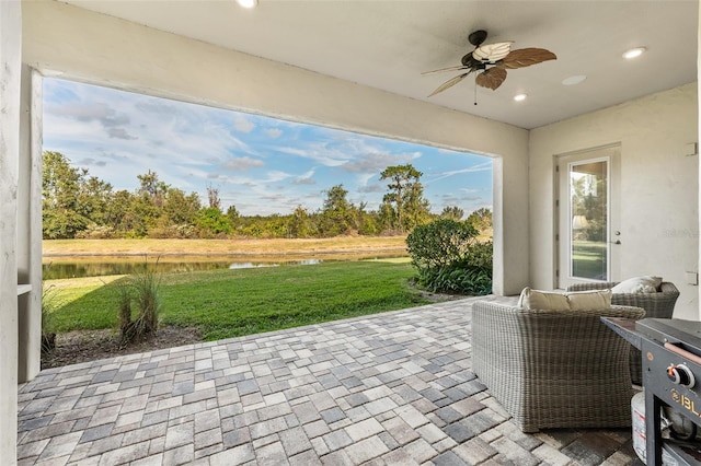 view of patio / terrace featuring ceiling fan and a water view