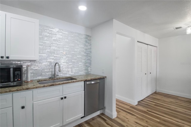 kitchen with white cabinets, stainless steel appliances, light hardwood / wood-style flooring, and sink