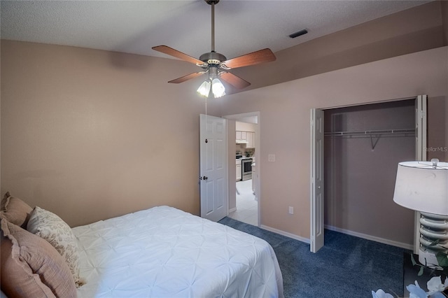 bedroom with carpet flooring, a textured ceiling, a closet, and ceiling fan