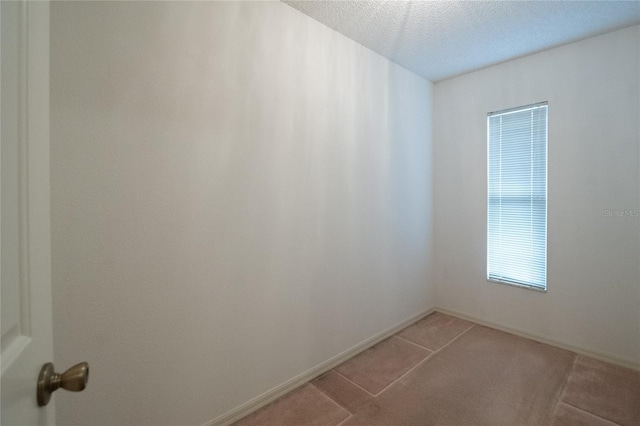 tiled spare room featuring a textured ceiling