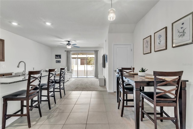 carpeted dining room with ceiling fan and sink