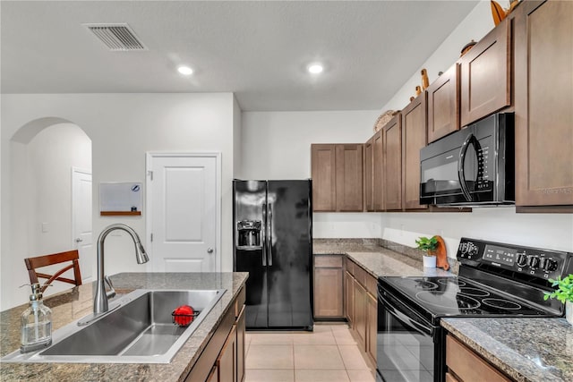 kitchen featuring black appliances, light tile patterned floors, and sink