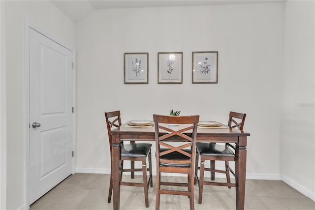 dining space featuring light tile patterned floors and lofted ceiling