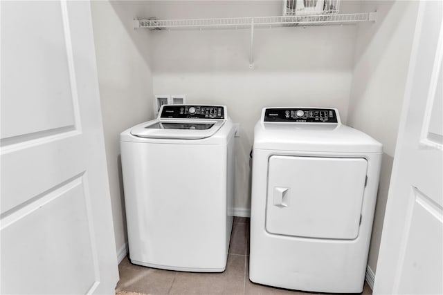 washroom with light tile patterned floors and washing machine and dryer