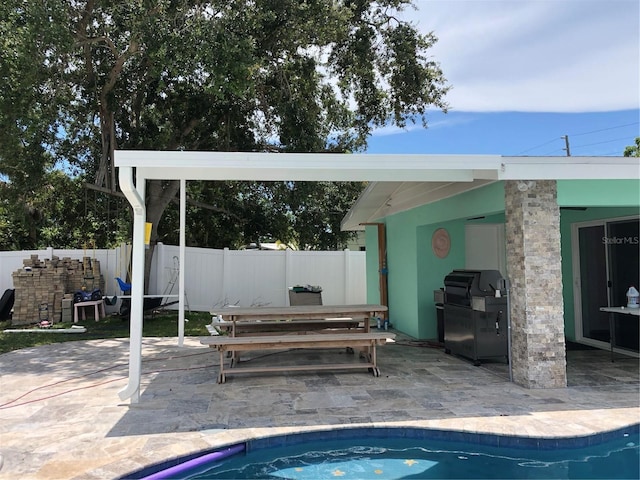 view of pool featuring a grill and a patio area