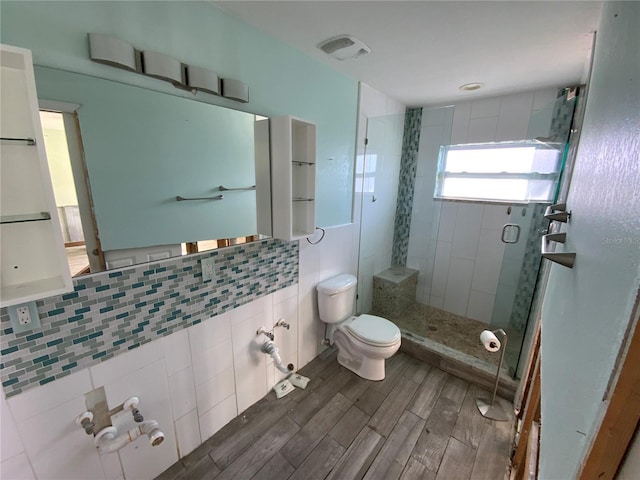 bathroom with tasteful backsplash, a shower with door, and toilet