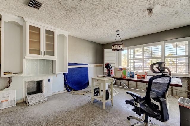 home office with light colored carpet and a textured ceiling