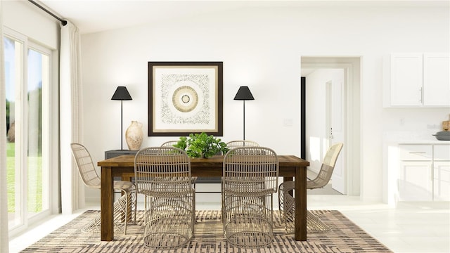 tiled dining space featuring plenty of natural light and lofted ceiling