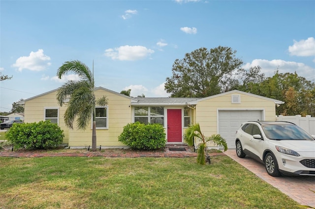 ranch-style home featuring a garage and a front lawn