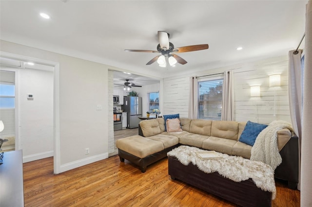 living room with ceiling fan and light wood-type flooring