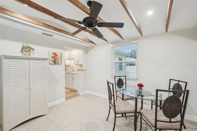 tiled dining area with vaulted ceiling with beams, ceiling fan, and sink