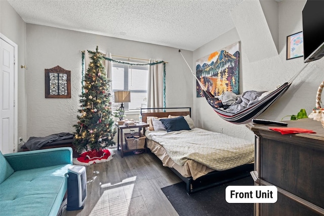 bedroom with wood-type flooring and a textured ceiling