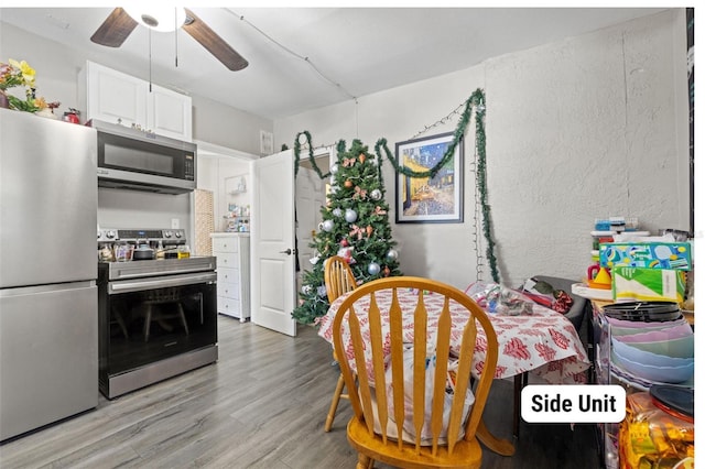 dining space with ceiling fan and light hardwood / wood-style flooring