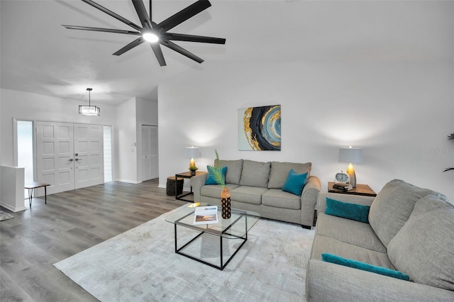 living room featuring ceiling fan, hardwood / wood-style floors, and vaulted ceiling