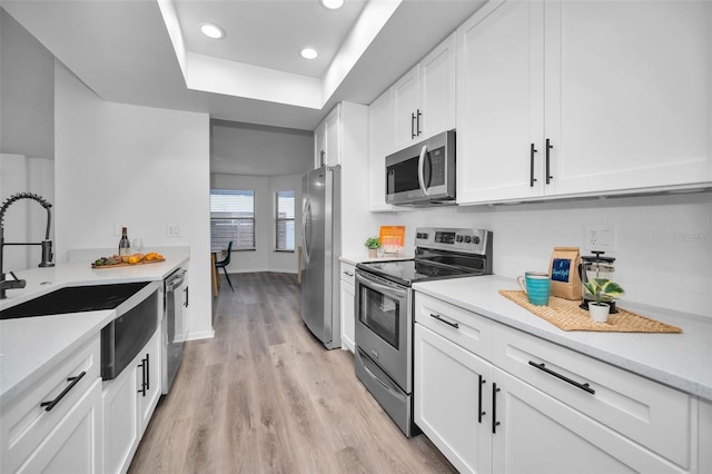 kitchen featuring white cabinets, light hardwood / wood-style floors, sink, and stainless steel appliances