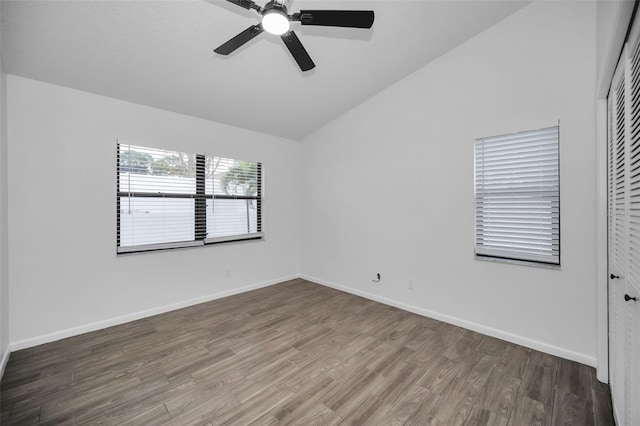 empty room with hardwood / wood-style flooring, vaulted ceiling, and ceiling fan