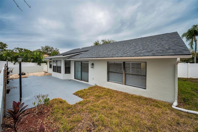 rear view of house with a yard and a patio