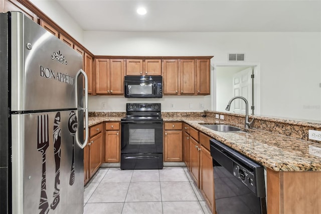 kitchen featuring light tile patterned floors, kitchen peninsula, black appliances, light stone counters, and sink