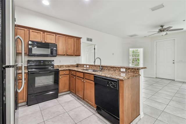 kitchen featuring ceiling fan, stone counters, black appliances, kitchen peninsula, and sink