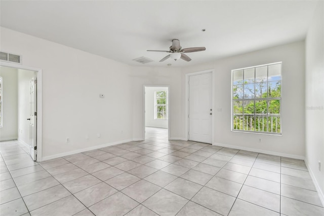 tiled empty room featuring ceiling fan