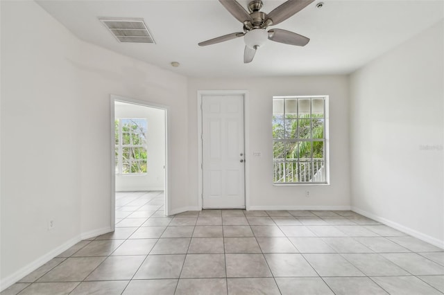 tiled spare room featuring ceiling fan