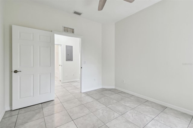 tiled empty room with ceiling fan and electric panel