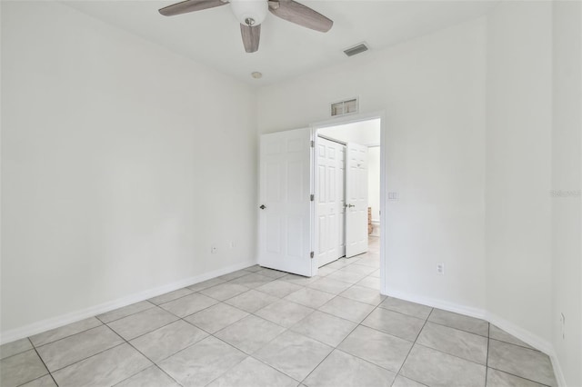 empty room with ceiling fan and light tile patterned flooring