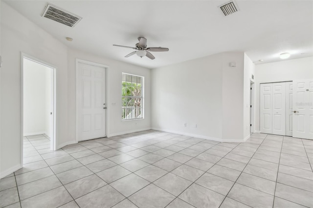 tiled spare room featuring ceiling fan