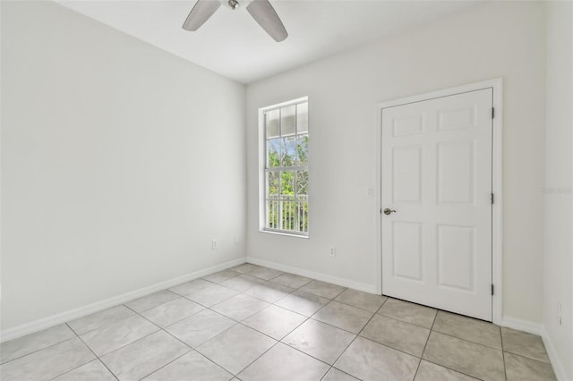 spare room with ceiling fan and light tile patterned flooring