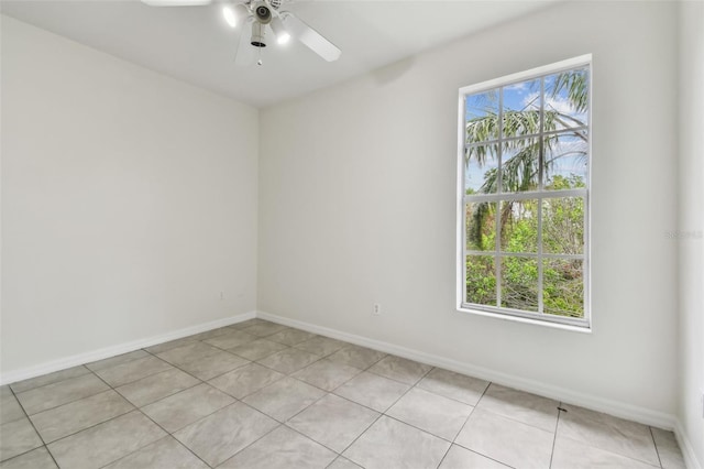 tiled spare room featuring ceiling fan