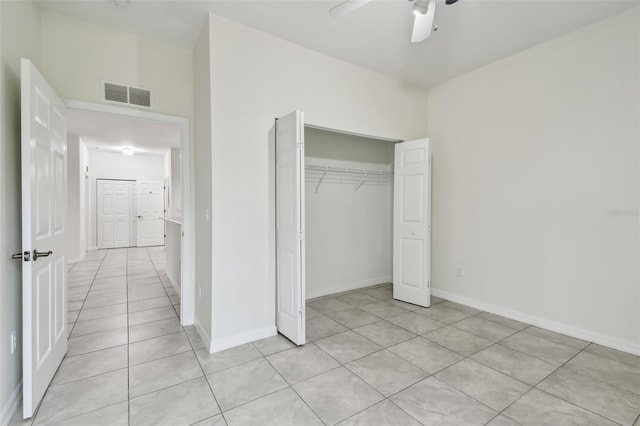 unfurnished bedroom featuring ceiling fan, light tile patterned floors, and a closet