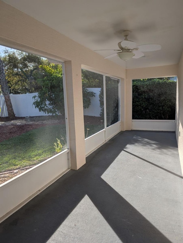 unfurnished sunroom featuring ceiling fan