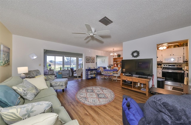 living room with hardwood / wood-style floors, ceiling fan with notable chandelier, and a textured ceiling