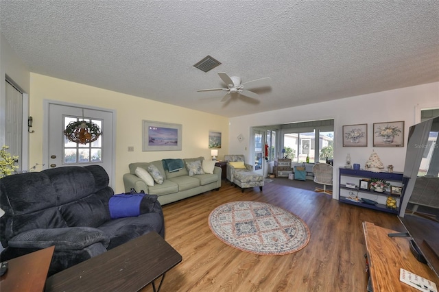 living room featuring a textured ceiling, hardwood / wood-style flooring, and ceiling fan